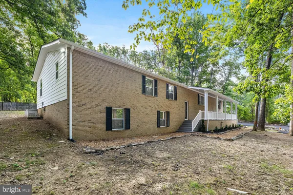 a view of a house with a backyard and a large tree