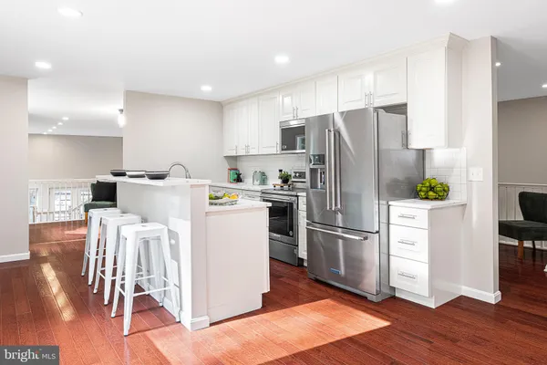 a kitchen with stainless steel appliances a refrigerator a stove top oven and a center island