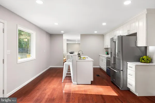 a kitchen with stainless steel appliances a refrigerator and wooden floor