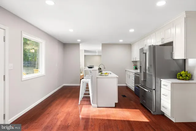 a kitchen with stainless steel appliances a refrigerator and wooden floor