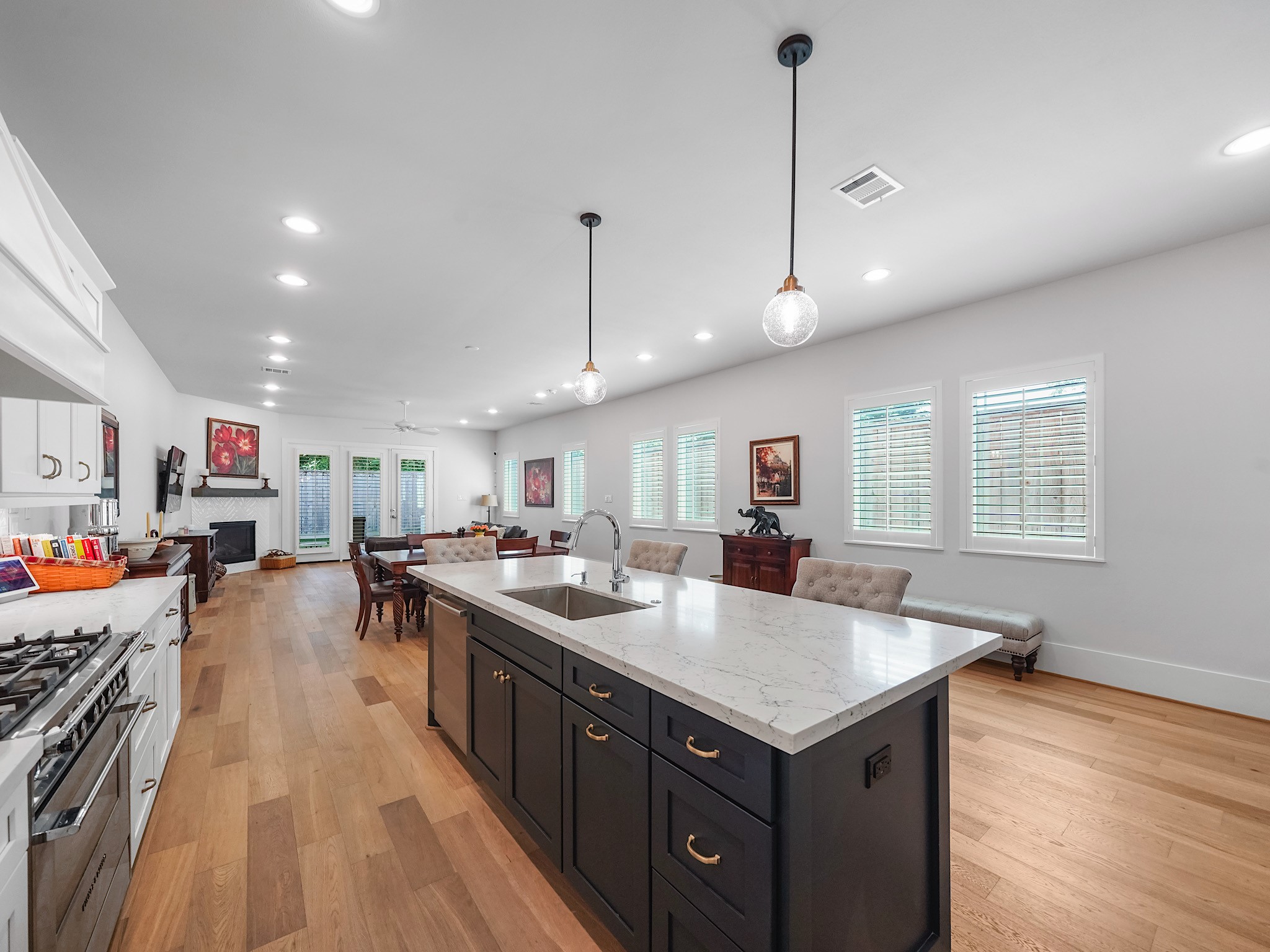 812 East 24th Street Houston, TX 77009 - Photo 8 of 36 a kitchen with a stove a refrigerator a sink dishwasher with a dining table and chairs with wooden floor