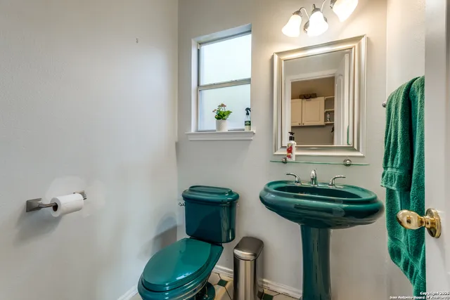 a bathroom with a sink a toilet and mirror