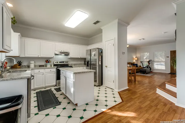a kitchen with a sink a refrigerator and cabinets