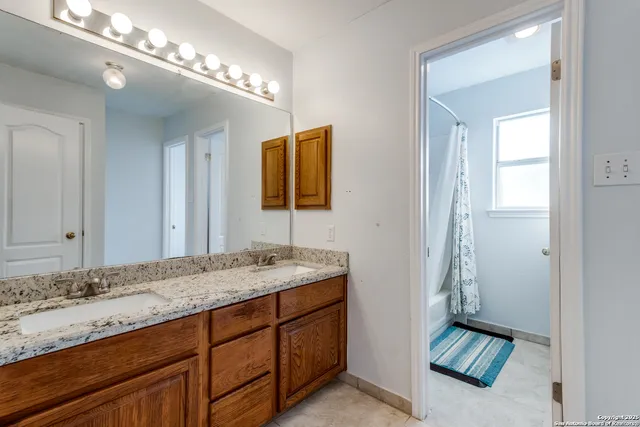 a bathroom with a granite countertop sink and a mirror