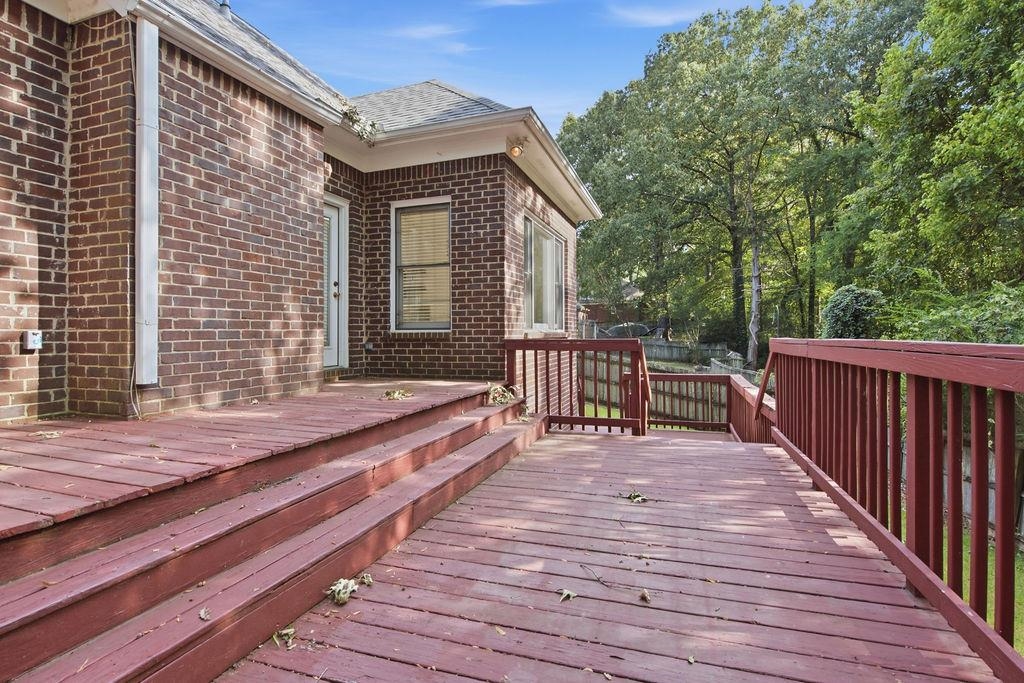 285 Great Falls Road Collierville, TN 38017 - Photo 29 of 29 Expansive multi-level wood deck with stained railings, featuring exterior brick siding and a white window with blinds