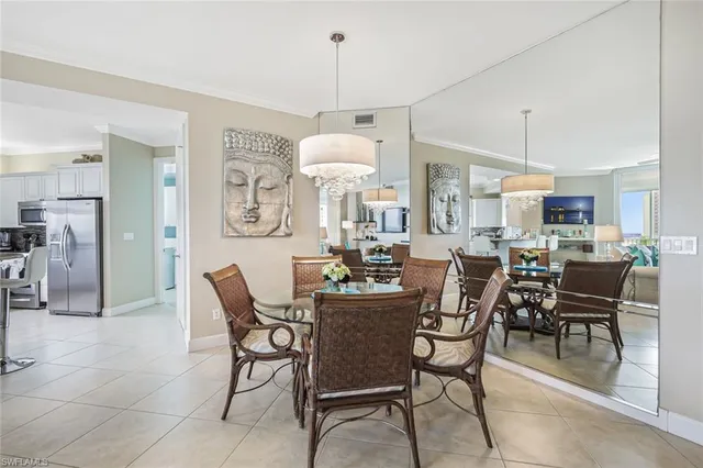 a dining room with wooden floor a chandelier a glass table and chairs