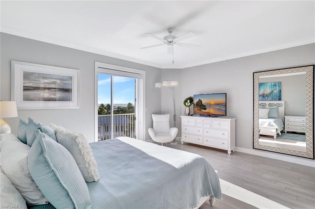 400 Flagship Drive, Unit 602 Naples, FL 34108 - Photo 13 of 37 a bedroom with a large bed and a chandelier