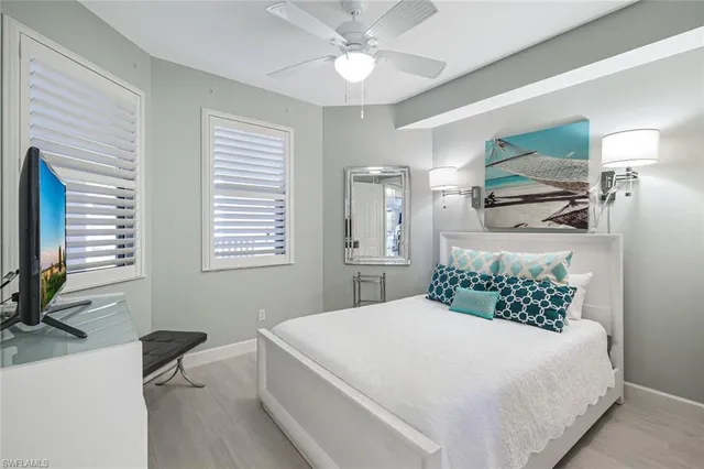 a bedroom with a large bed a flat tv screen and a dresser