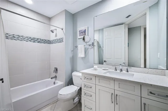 a bathroom with a double vanity sink toilet mirror and bathtub