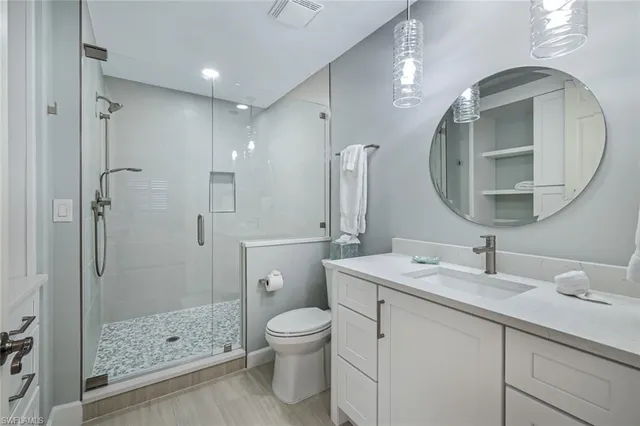a bathroom with a sink a toilet and shower