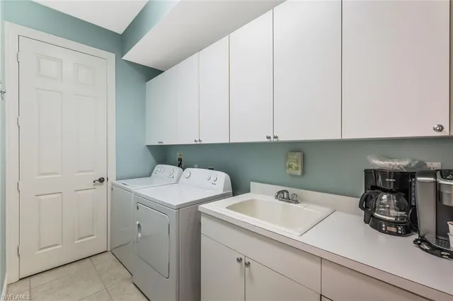 a utility room with sink dryer and washer