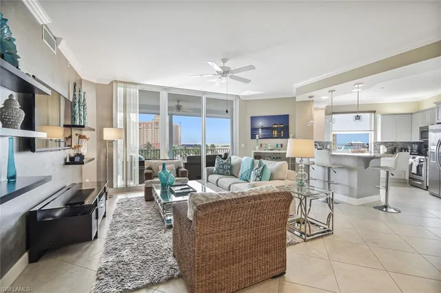 a living room with furniture potted plant and kitchen view
