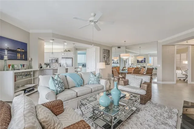 a living room with furniture kitchen view and a wooden floor