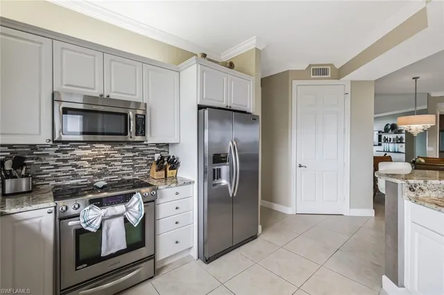 a kitchen with stainless steel appliances granite countertop a stove a refrigerator and a microwave