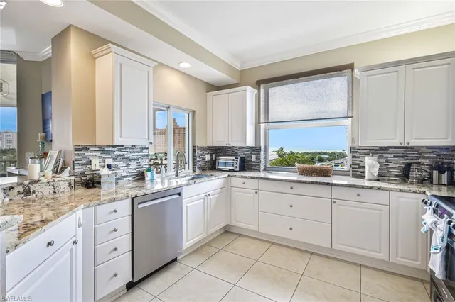 a large white kitchen with cabinets