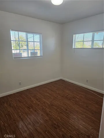 a view of a room with wooden floor and window