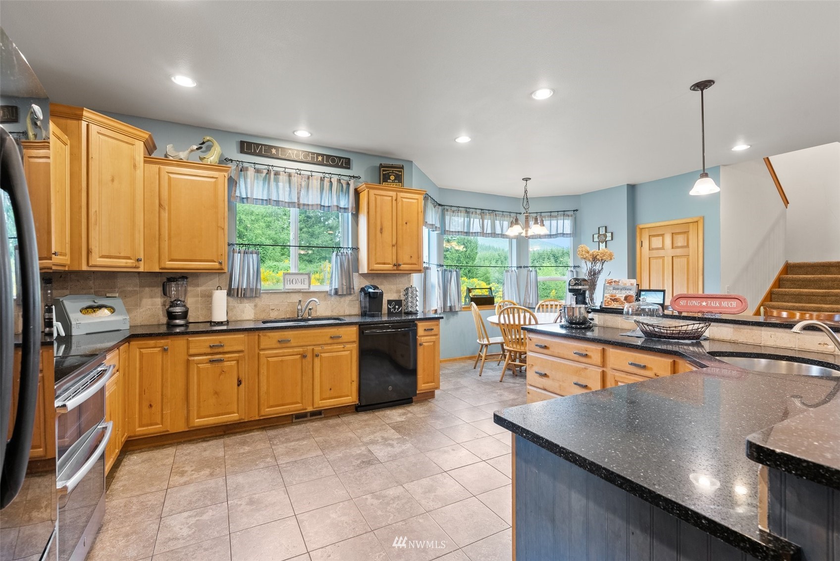 356 Wells Road Pe Ell, WA 98572 - Photo 14 of 40 a large kitchen with kitchen island granite countertop a large counter top stainless steel appliances a sink cabinets and a window