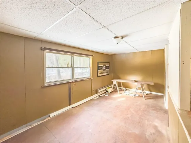 an empty room with wooden floor and a ceiling fan