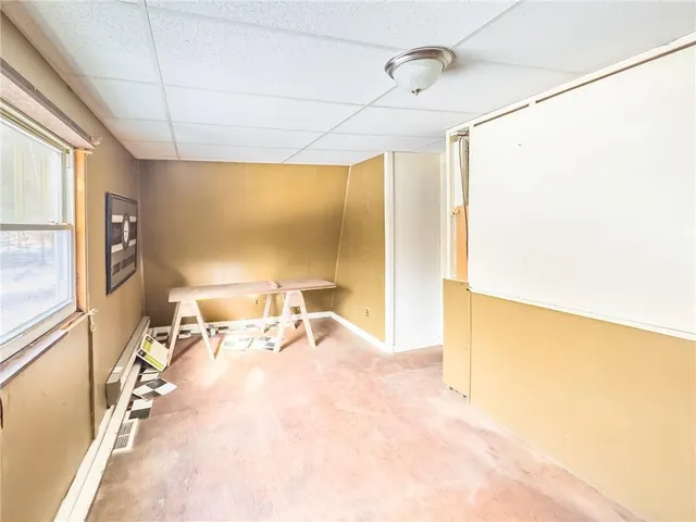 an empty room with a ceiling fan and carpet