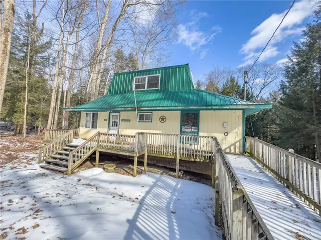 a front view of house with deck and outdoor seating
