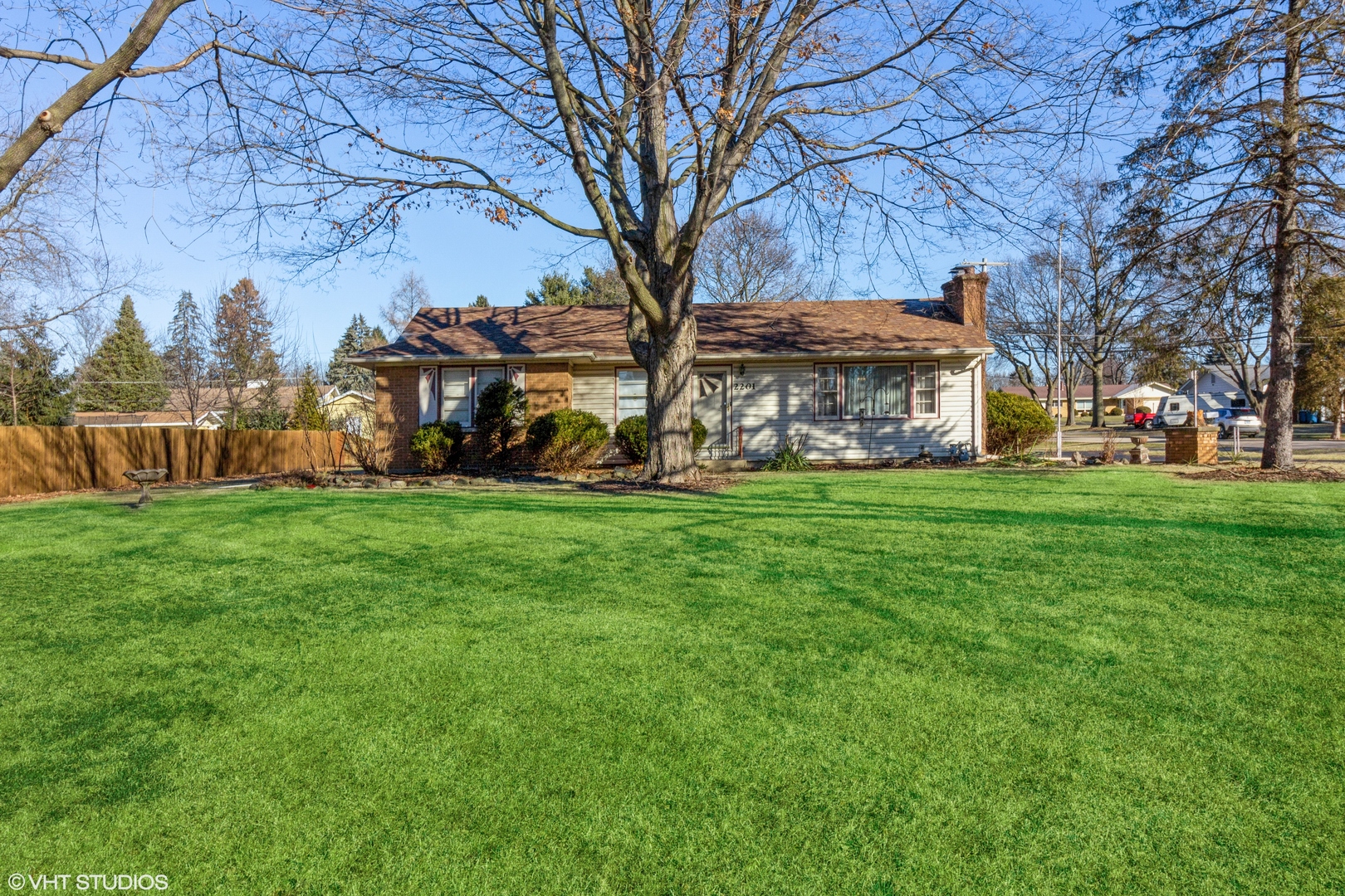 a view of a house with a big yard and large trees
