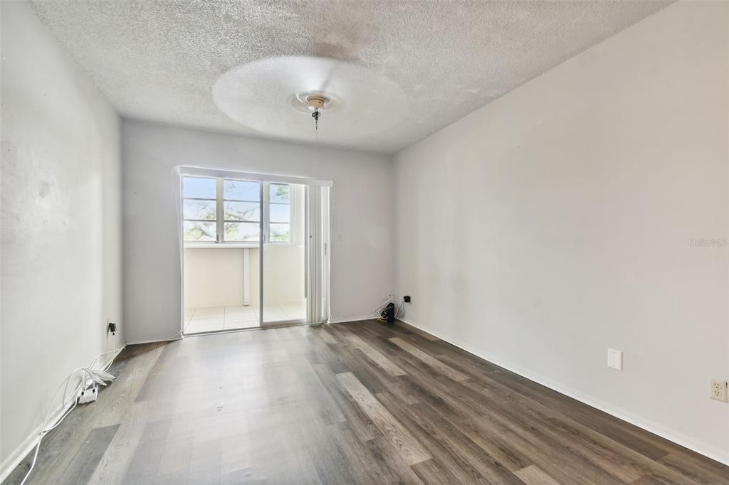 645 North Keene Road, Unit D Clearwater, FL 33755 - Photo 11 of 27 an empty room with wooden floor and windows