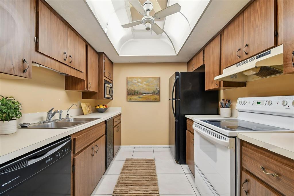 645 North Keene Road, Unit D Clearwater, FL 33755 - Photo 3 of 27 a kitchen with stainless steel appliances granite countertop a sink stove and refrigerator