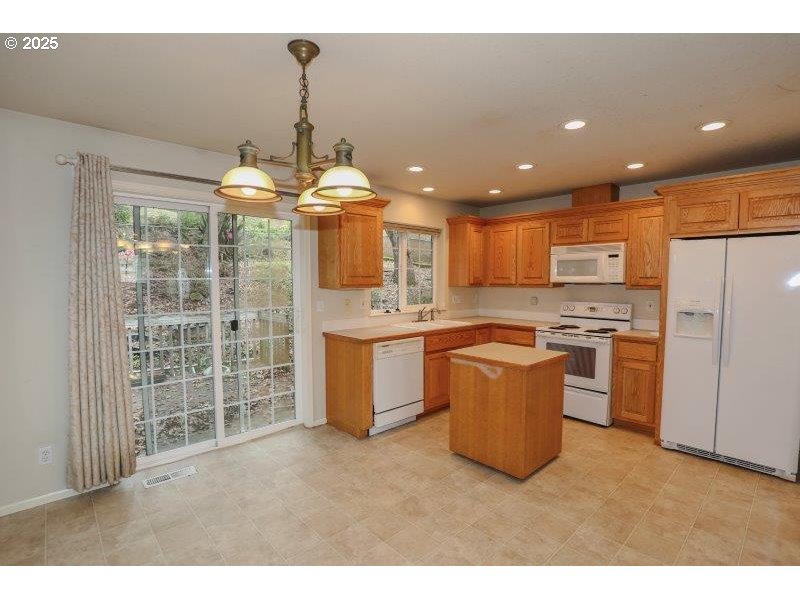 1147 Southeast Kane Street Roseburg, OR 97470 - Photo 11 of 41 a kitchen with stainless steel appliances kitchen island granite countertop a stove a sink a refrigerator and a refrigerator