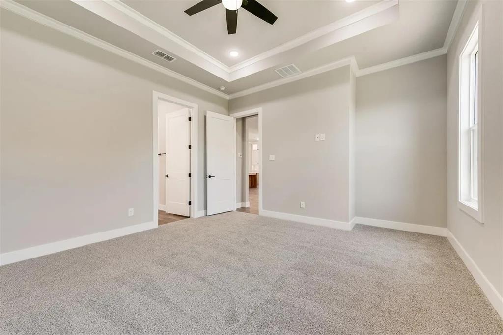 1327 Selby Road Van Alstyne, TX 75495 - Photo 22 of 32 Unfurnished bedroom featuring a tray ceiling, light colored carpet, multiple windows, ceiling fan, and crown molding