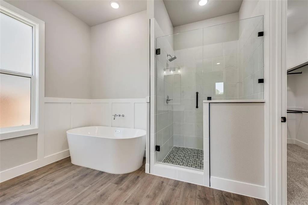 1327 Selby Road Van Alstyne, TX 75495 - Photo 25 of 32 Full bathroom with a freestanding bath, wood finished floors, a stall shower, a wainscoted wall, and a decorative wall