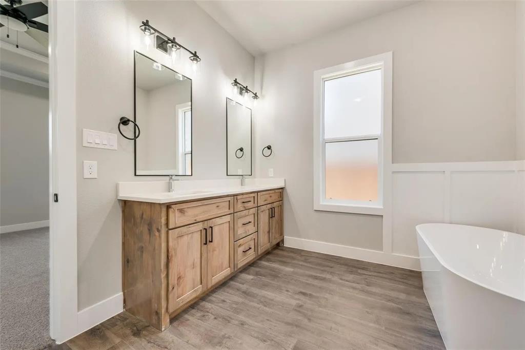 1327 Selby Road Van Alstyne, TX 75495 - Photo 27 of 32 Full bathroom with double vanity, a freestanding bath, light wood finished floors, and wainscoting