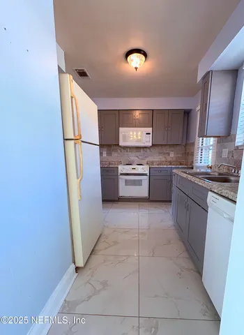 a kitchen with a refrigerator and a sink