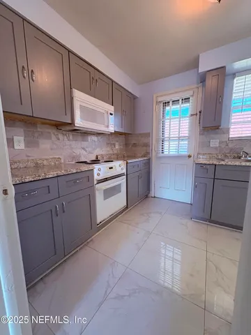 a kitchen with cabinets stove top oven and sink