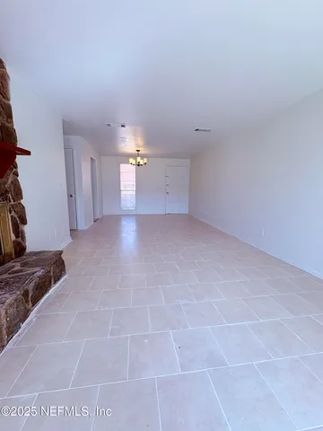a view of a livingroom with an empty space and a stove