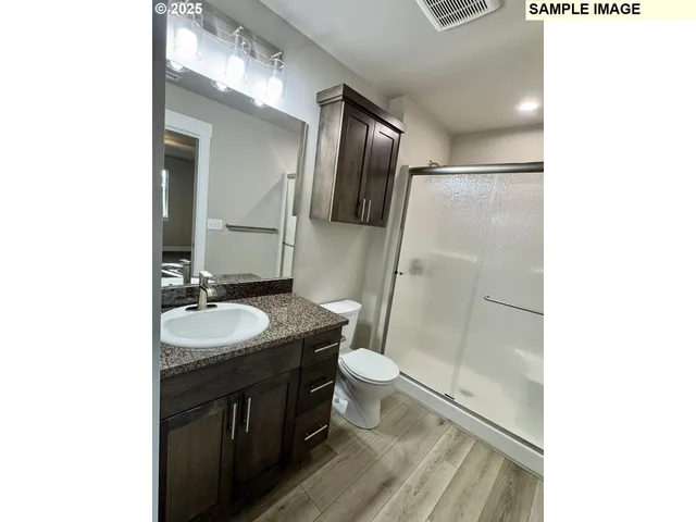 a bathroom with a double vanity sink toilet and shower