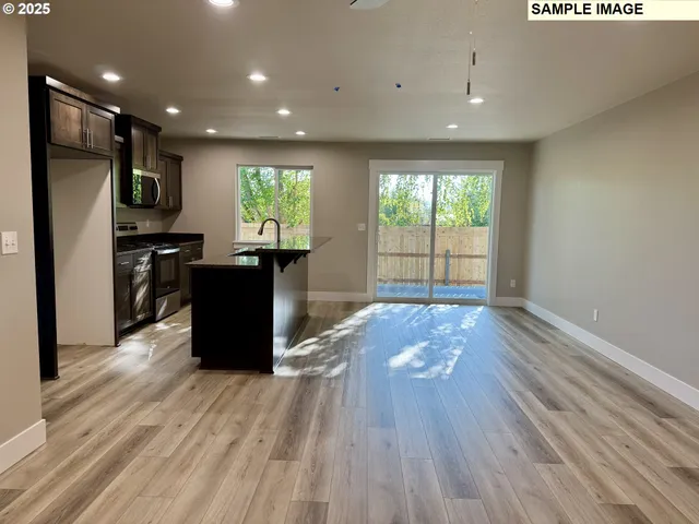 a view of kitchen with refrigerator microwave and wooden floor