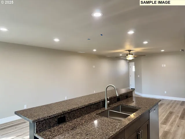 a kitchen with granite countertop a sink and a stove