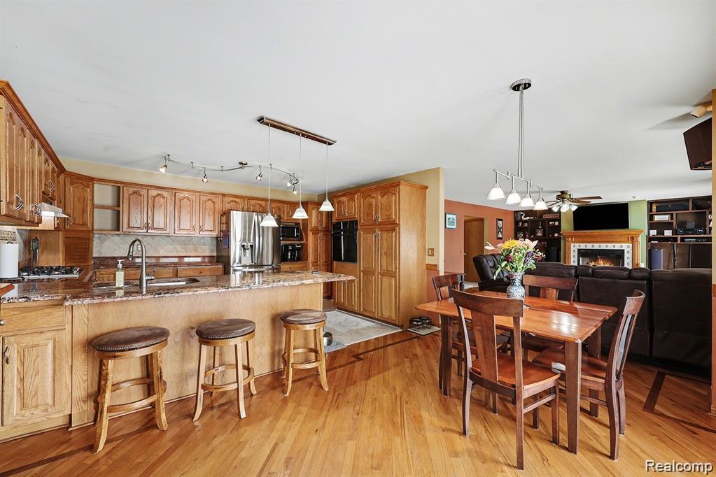 7277 Cardinal Road Algonac, MI 48001 - Photo 19 of 36 Kitchen with dark stone countertops, a peninsula, a ceiling fan, a kitchen bar, and track lighting