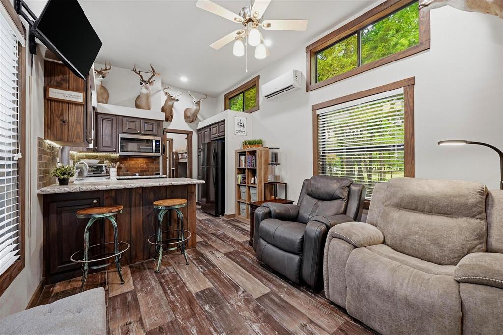 3958 Ranch Road Whitesboro, TX 76273 - Photo 9 of 40 Open-concept living space with wood-finish flooring, vaulted ceilings, and upper transom windows