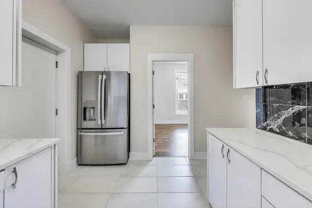 a kitchen with a refrigerator sink and cabinets