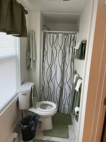 a white toilet sitting next to a shower curtain