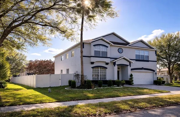 a view of a yard in front of a house with large tree