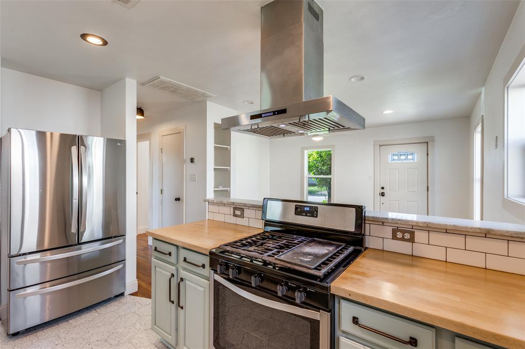 2012 Payne Avenue, Unit A Austin, TX 78757 - Photo 14 of 33 Kitchen featuring a stainless steel range hood, built-in range, wood countertops, subway tile backsplash, and light-toned cabinetry