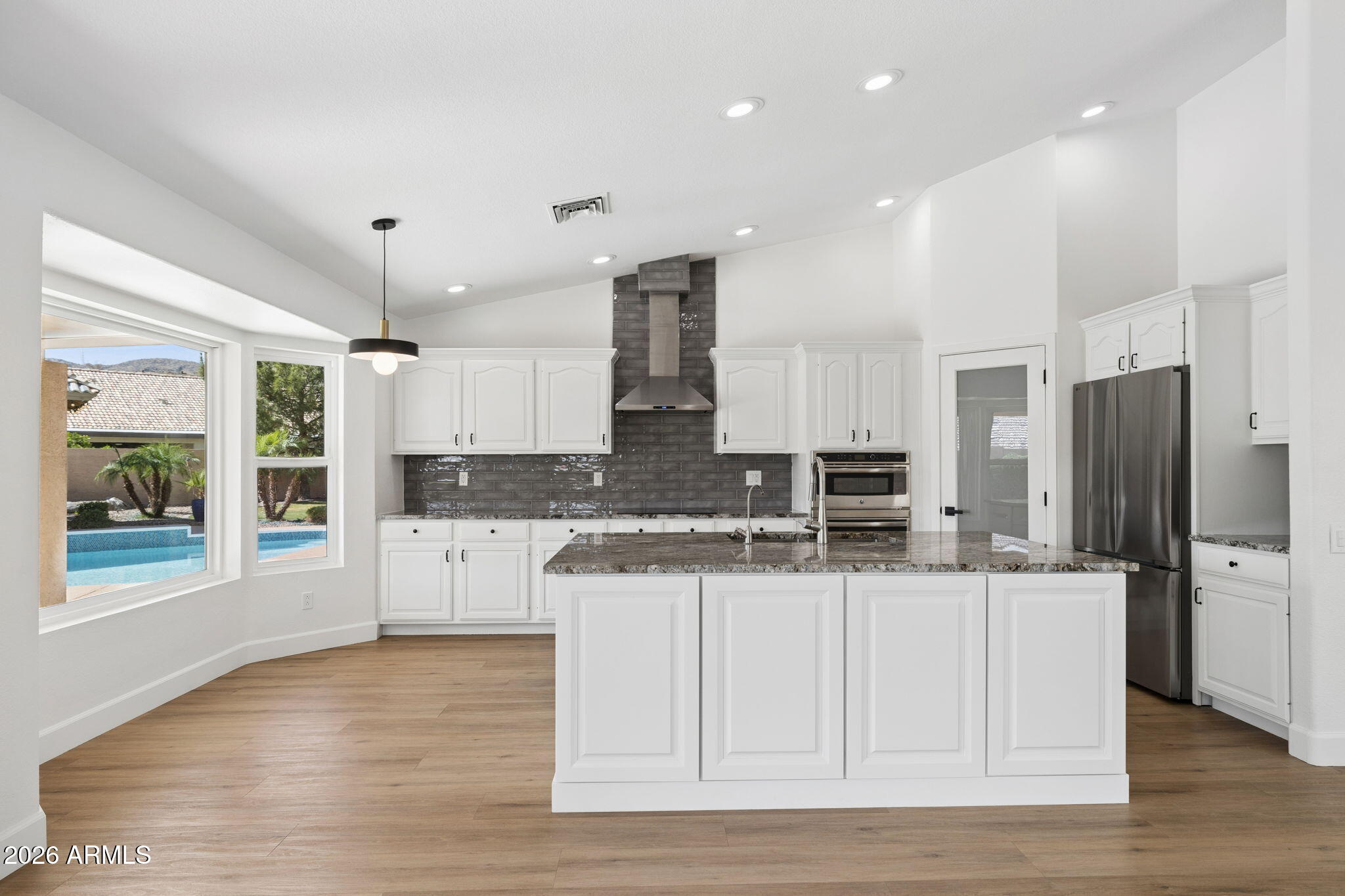 2451 East Dry Creek Road Phoenix, AZ 85048 - Photo 17 of 56 a kitchen with stainless steel appliances kitchen island granite countertop a refrigerator and a stove top oven