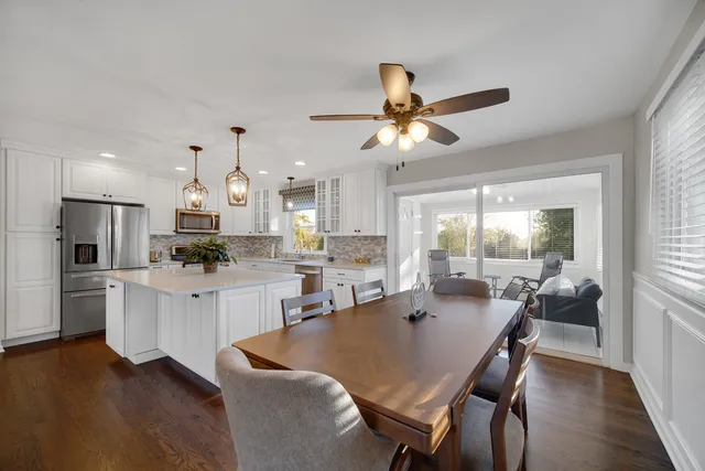 a open dining room with stainless steel appliances kitchen island granite countertop furniture and wooden floor