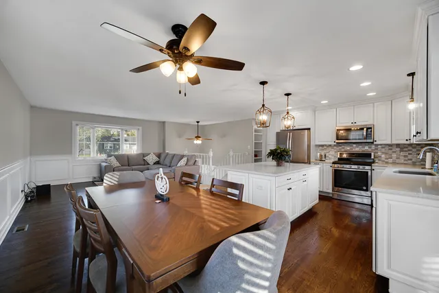 a open dining room with stainless steel appliances kitchen island granite countertop furniture and a kitchen view