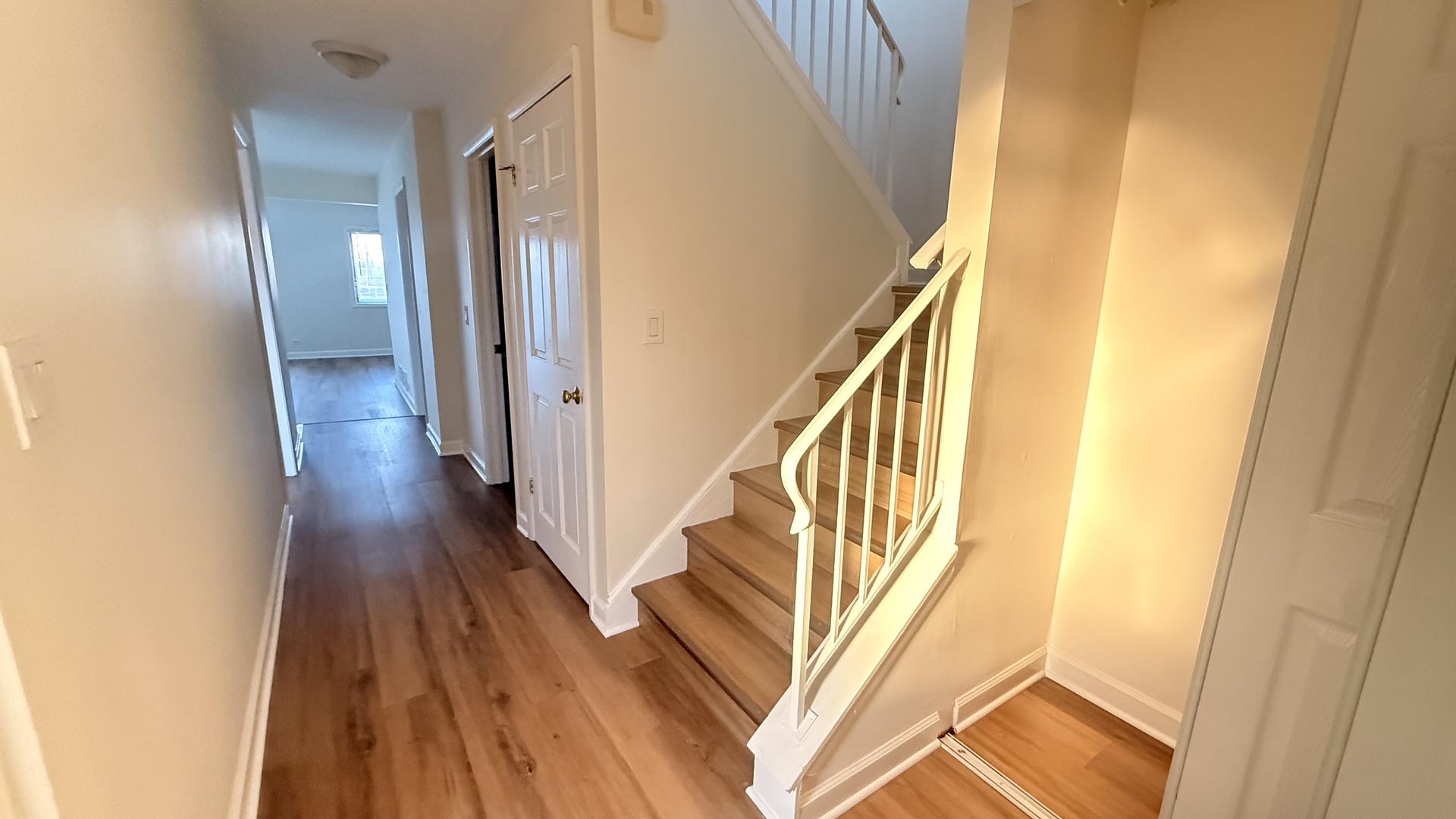 604 Bayview Point, Unit 604 Schaumburg, IL 60194 - Photo 3 of 17 a view of a hallway with wooden floor and staircase