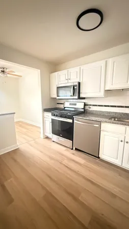 a kitchen with stainless steel appliances granite countertop a stove a sink and a microwave