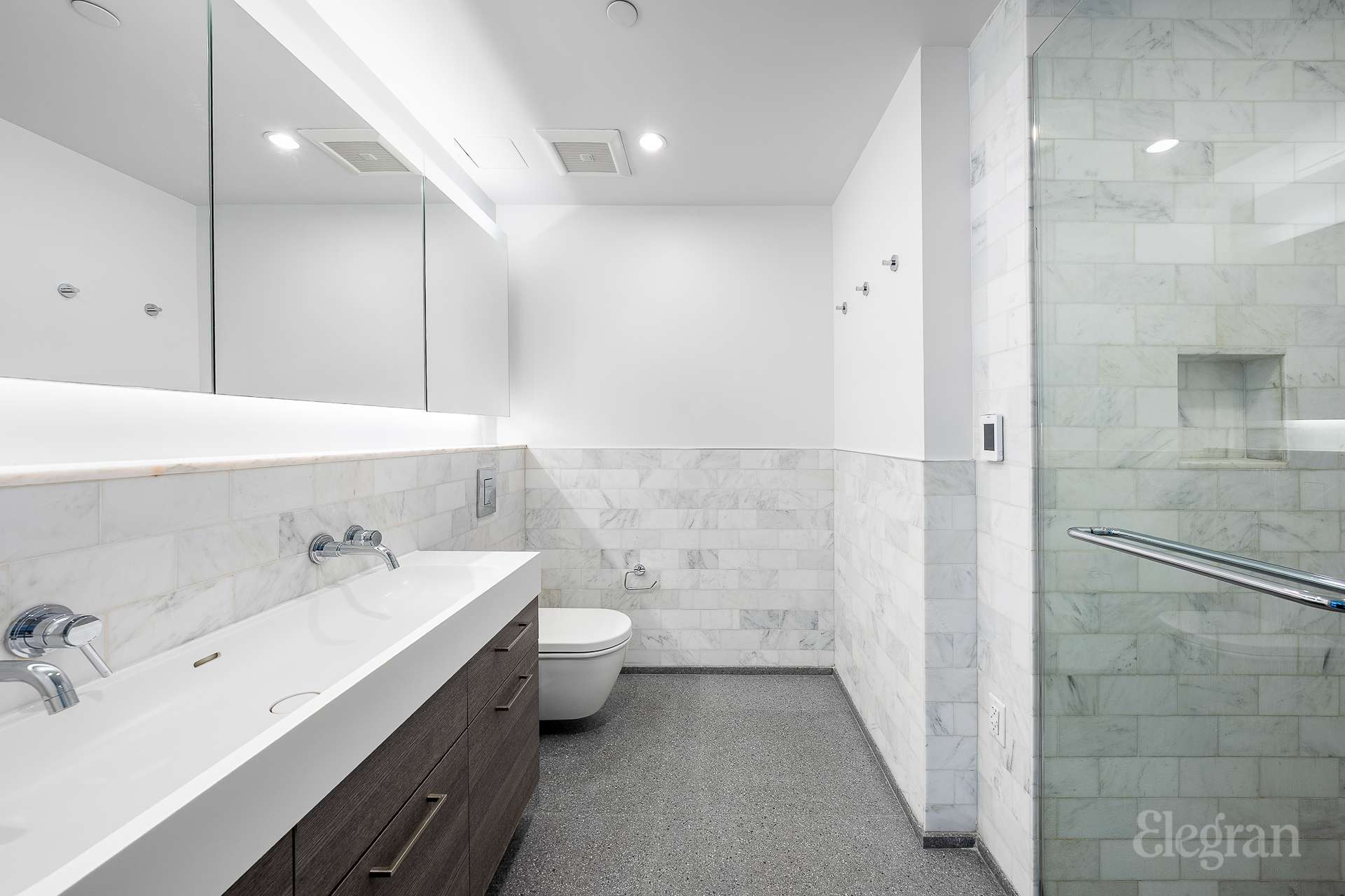 591 3rd Avenue, Unit 12A Manhattan, NY 10016 - Photo 7 of 14 a bathroom with a double vanity sink mirror and toilet