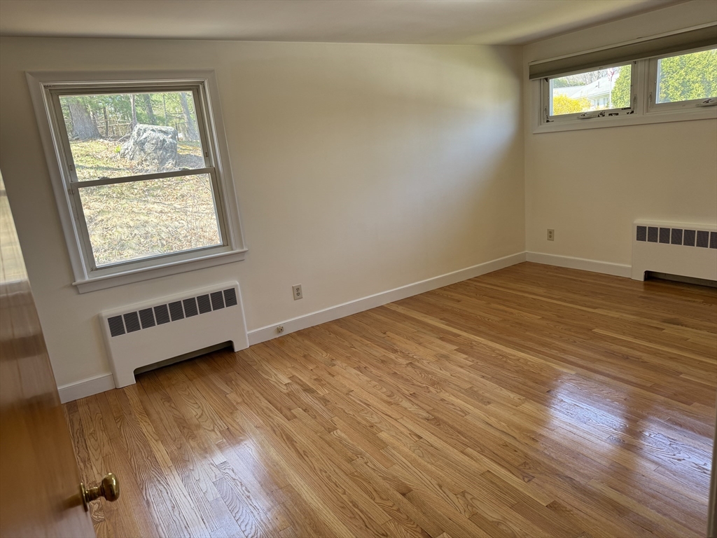 174 Forest Street Waltham, MA 02452 - Photo 3 of 15 a view of an empty room with wooden floor and a window